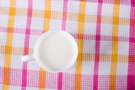 Mug of milk on a checkered tableclothの写真素材
