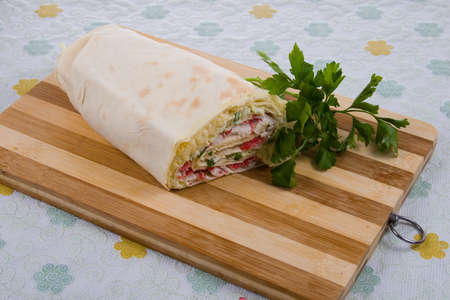 Pita roll with crab sticks on a wooden boardの写真素材