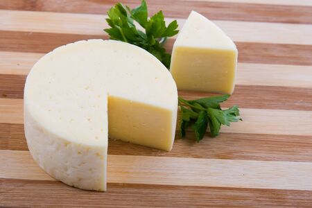 Round cheese on a wooden boardの写真素材
