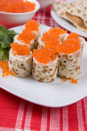 Rolls from pancakes with red caviar on a plate.The celebration of Maslenitsa - Russian religious and folk holiday.の写真素材