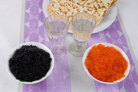 Vodka, pancakes, red and black caviar on a tableの写真素材