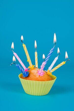 Festive cupcake with a candles on gradient backgroundの写真素材