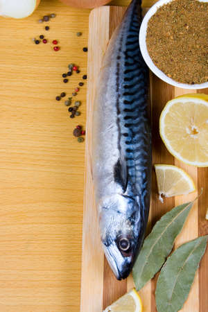 Raw mackerel and spices on a wooden tableの写真素材