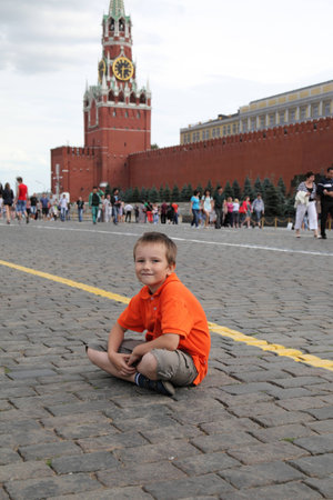 Happy boy sitting on the cobblestones of Red Square in Moscowのeditorial素材