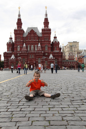 Happy boy sitting on the cobblestones of Red Square in Moscowのeditorial素材