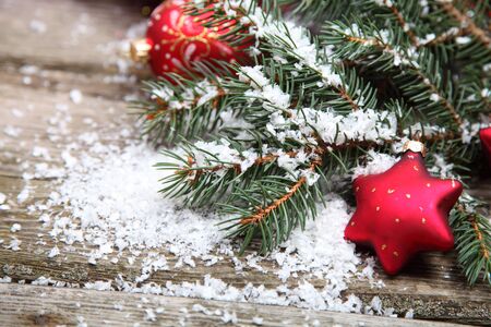 Red Christmas decoration on spruce branches with snowの写真素材