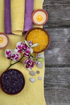 Spa still life: soap, salt for baths, a flower and towels on a wooden backgroundの写真素材