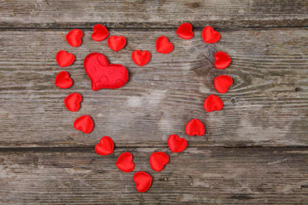 Heart of red small hearts on a wooden background. Valentines day background.