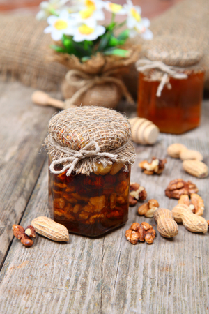 Honey in the pot and nuts on wooden backgroundの写真素材