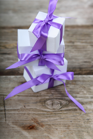 Boxes with gifts tied bows on a wooden backgroundの写真素材