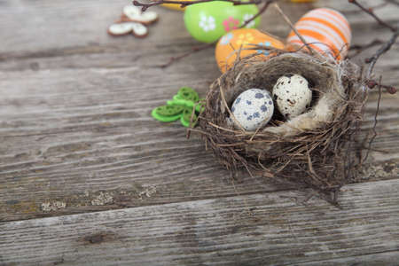 Easter still life with eggs in the nest on a wooden background