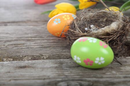Easter composition with nest and eggs on a wooden table