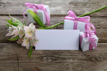 White alstroemeria, gifts and greetings card on the wooden tableの写真素材