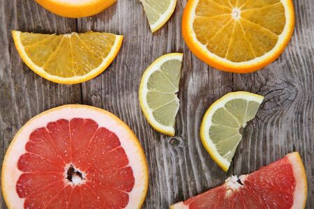 Oranges, grapefruits and lemons on a wood table backgroundの写真素材