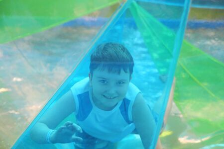 Cheerful boy on the attraction outdoorsの写真素材