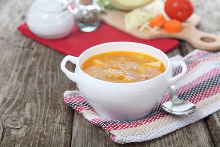 Cabbage soup in a white plate on old wooden table .の写真素材