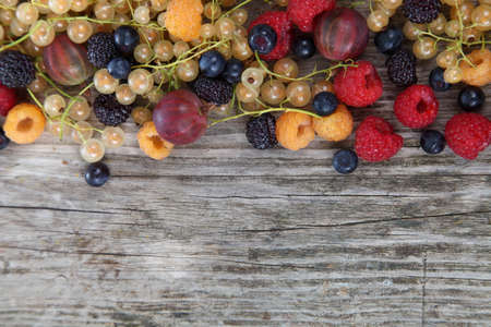 Different ripe berries on a wooden  tableの写真素材