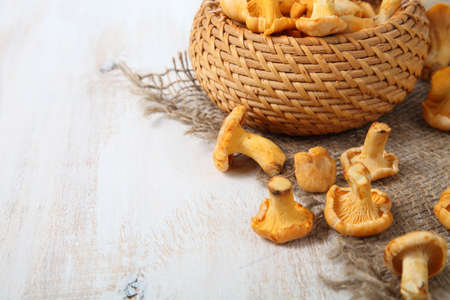 Chanterelles in a basket on a wooden tableの写真素材