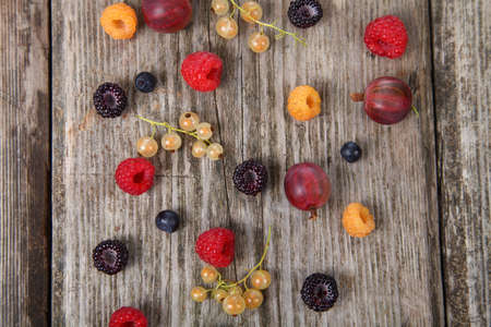 Different ripe berries on an old wooden table