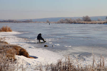 Fishermen on the snow-covered lake. Winter landscape.の写真素材