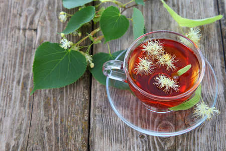 Herbal tea with linden on an old wooden tableの写真素材