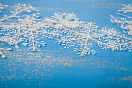 White snowflakes on a blue wooden background. Christmas composition.の写真素材