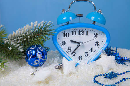 Christmas decorations and clock in the snow on a blue backgroundの写真素材