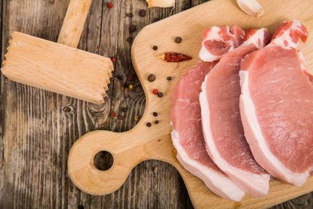 Raw meat with spices on a wooden tableの写真素材