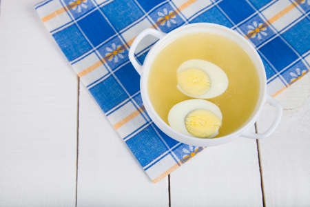 Chicken broth with egg on wooden tableの写真素材