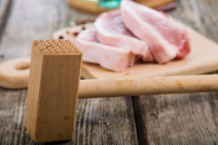 Raw meat with spices on a wooden tableの写真素材