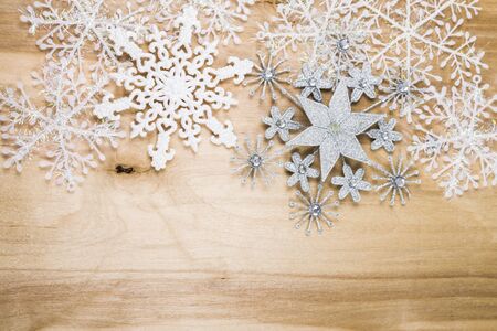 Silver snowflakes on a wooden table. Christmas decorations closeup.の写真素材