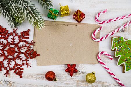 Christmas decoration and old paper on blue wooden table. Snowflakes, gifts, candies and fir branches...