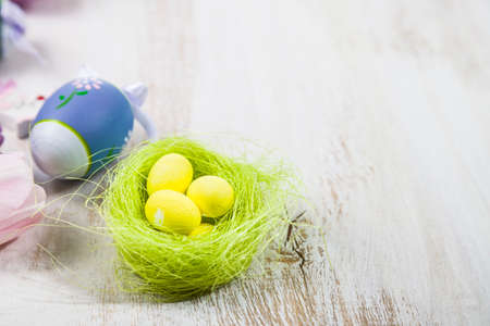 Bouquet purple tulips and Easter eggs on a light wooden table. Easter still life can be used as a postcard.の写真素材