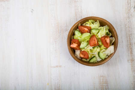 Salad in wooden bowl on a table close-up. Concept of healthy nutrition and diet.の写真素材