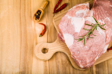 Raw pork on a wooden cutting board. Pork and spices on the table. Cooking.の写真素材