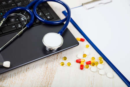 Doctor workplace with a stethoscope at wooden table. Health care concept.の写真素材