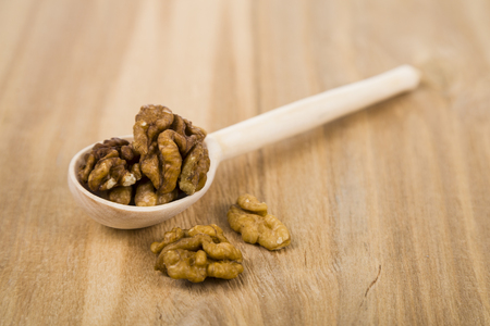 Walnuts in a spoon on a wooden table close up. Tasty and healthy nuts.