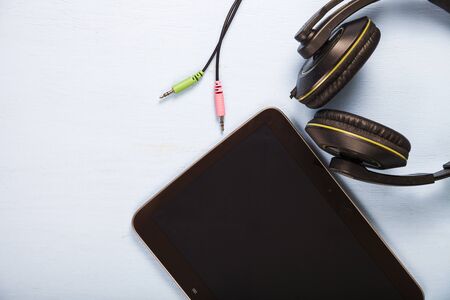Tablet and headphones on a blue wooden table close-upの写真素材