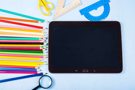 Back to school. Items for school and tablet on a blue wooden table.の写真素材