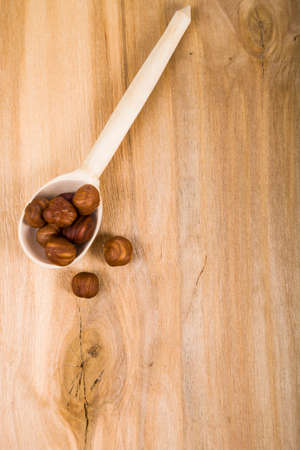 Almonds in a spoon on a wooden table close-up. Tasty and healthy nuts. Top view.の写真素材