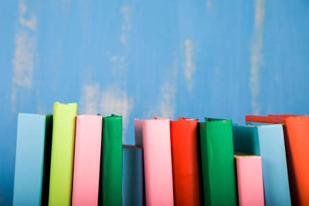 Stack of books on a blue background. A lot of books are close-up.の写真素材