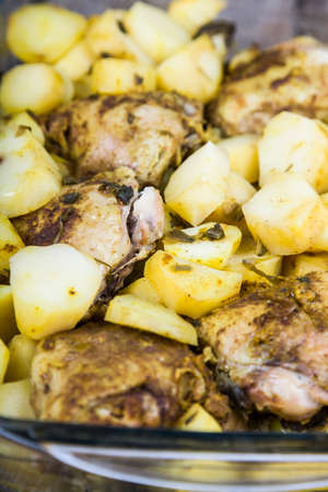 Potatoes with chicken baked in the oven. Delicious dish for dinner on a wooden tableの写真素材