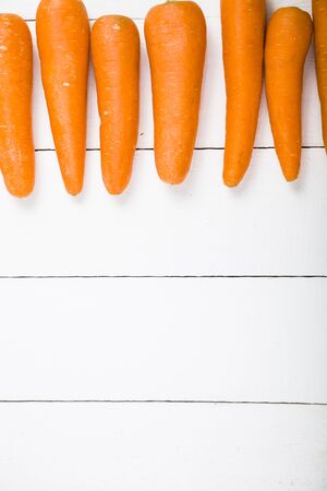 Grate the carrots in a bowl on a wooden table. Tasty and healthy food.の写真素材