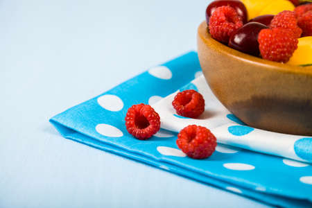 Ripe berries in a plate on a wooden table. Delicious and healthy dessert close-up, healthy diet.の写真素材