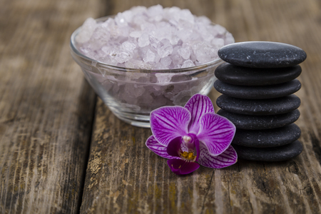 Spa treatments on wooden table. Sea salt, soap and orchid close-up.の写真素材