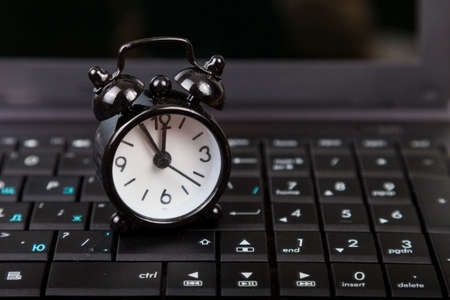 Black alarm clock on laptop.Time for business or the Internet.の写真素材