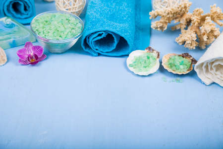 Spa treatments on a blue wooden table. Sea salt, soap and orchid close-up.の写真素材