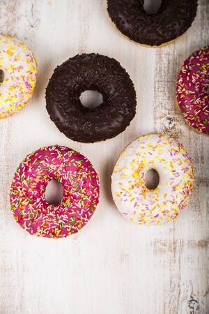 Multicolored donuts close-up on a wooden background. Delicious dessert.の写真素材