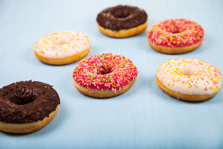 Multicolored donuts close-up on a wooden background. Delicious dessert.
