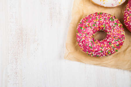 Multicolored donuts close-up on a wooden background. Delicious dessert.の写真素材